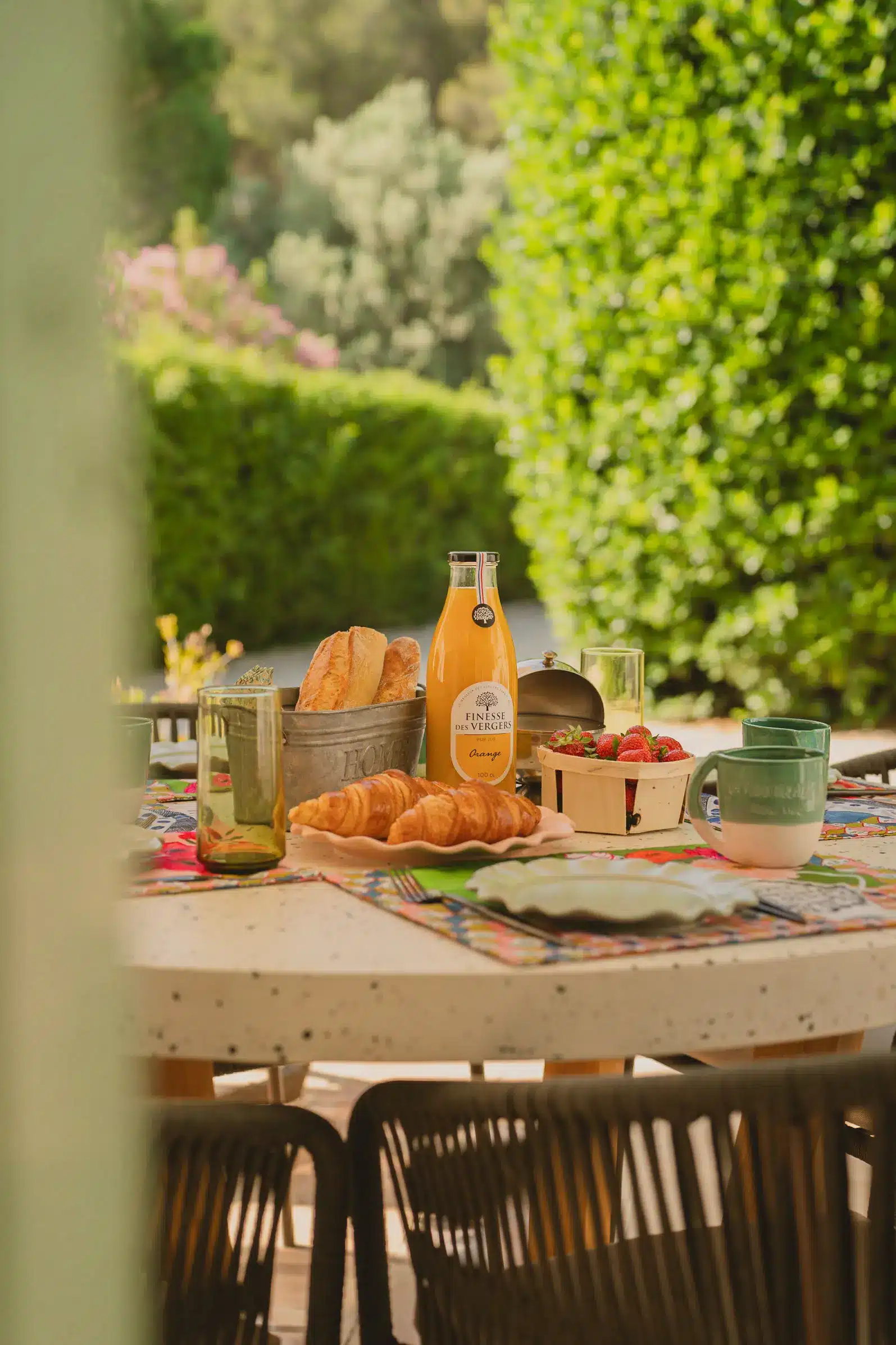 Petit-déjeuner en extérieur au gîte La Roucoulade en Provence, table dressée avec produits frais dans un jardin arboré